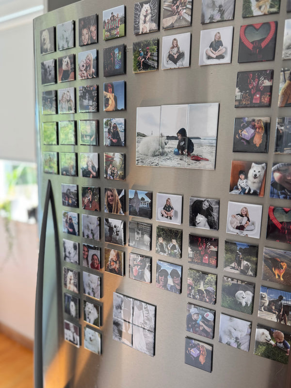 Fridge with a collage of small photo magnets  attached to it.