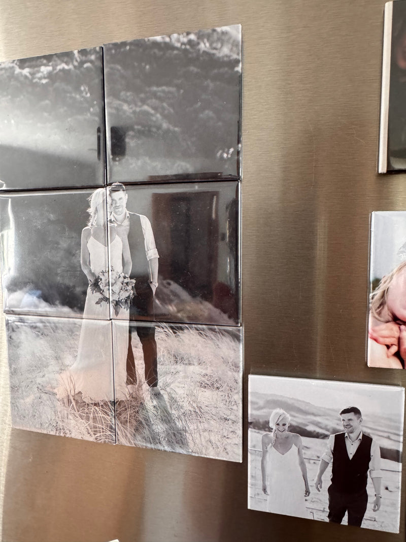 Fridge with decorative photo tiles and magnets on a metallic surface