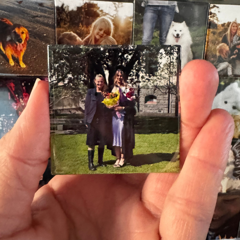 Hand holding a 2” x 2” photo magnet of graduation photo